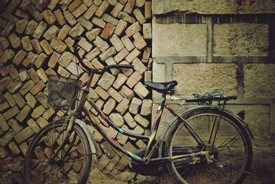 Bicycle parked against brick wall