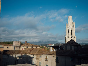 Buildings in town against cloudy sky