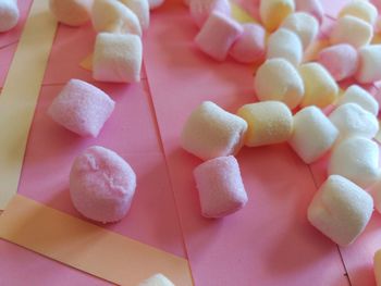 High angle view of marshmallows on pink paper