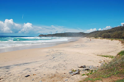 Scenic view of beach against blue sky