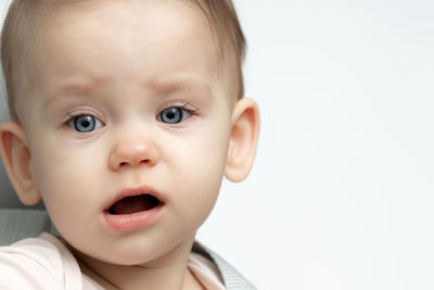 Close-up of cute baby boy against white background