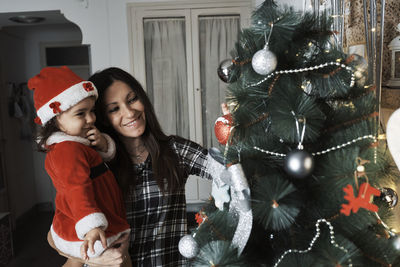 Women in illuminated christmas tree during winter