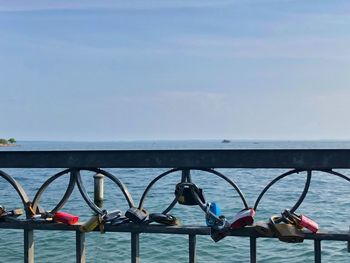 Padlocks on railing against sea