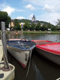 Boats moored in lake against sky
