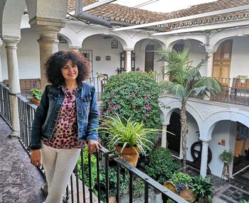 Young woman standing by potted plants