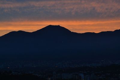 Scenic view of silhouette mountains against romantic sky at sunset