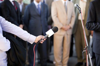 Journalist taking interview while holding microphone