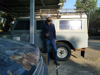 Portrait of man standing at a jeep car