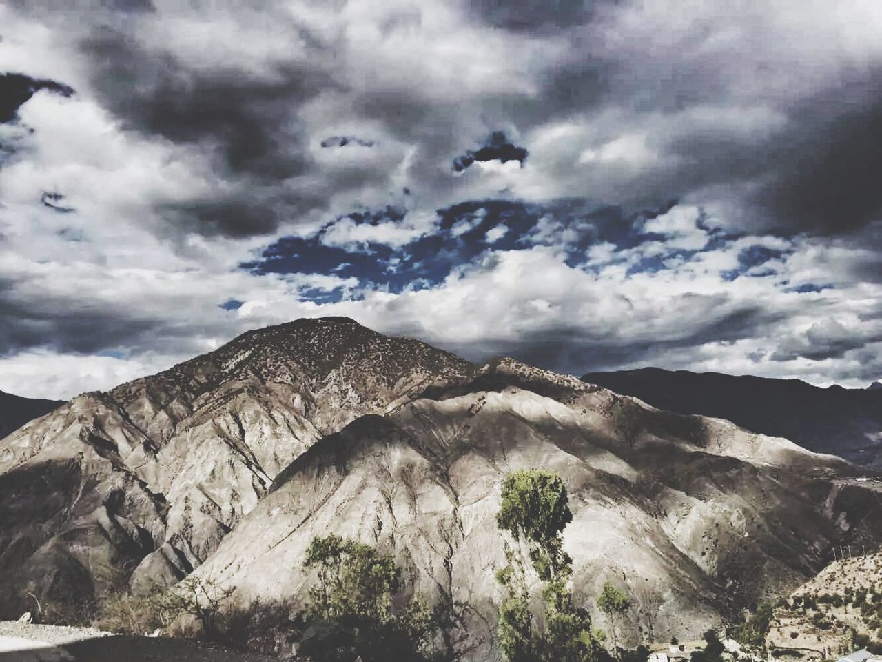 sky, mountain, cloud - sky, cloudy, tranquil scene, tranquility, scenics, beauty in nature, cloud, nature, mountain range, landscape, low angle view, rock - object, non-urban scene, weather, day, rock formation, rocky mountains, idyllic