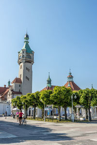 View of buildings in city against clear blue sky