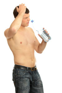 Midsection of shirtless man standing against white background