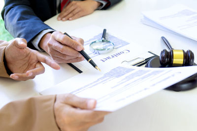 Midsection of man holding paper at table