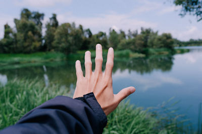 Midsection of person against plants in lake