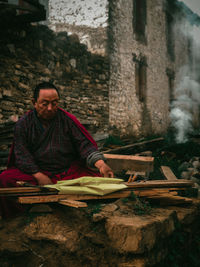 Portrait of old monk sitting on wood to start his ritual for the newly constructed palace