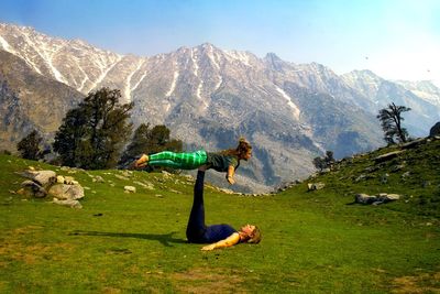 Person on field by mountains against sky