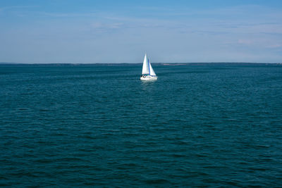 Sailboat sailing on sea against sky