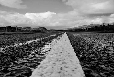 Surface level of road on field against sky