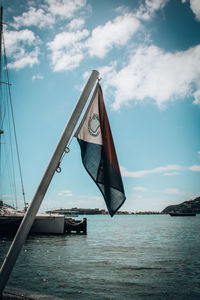 Sailboat flag on sea against sky