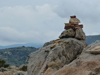 Stack of rocks on mountain against sky