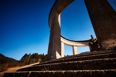 Low angle view of memorial against clear blue sky
