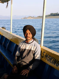 Portrait of man sitting in boat against sea
