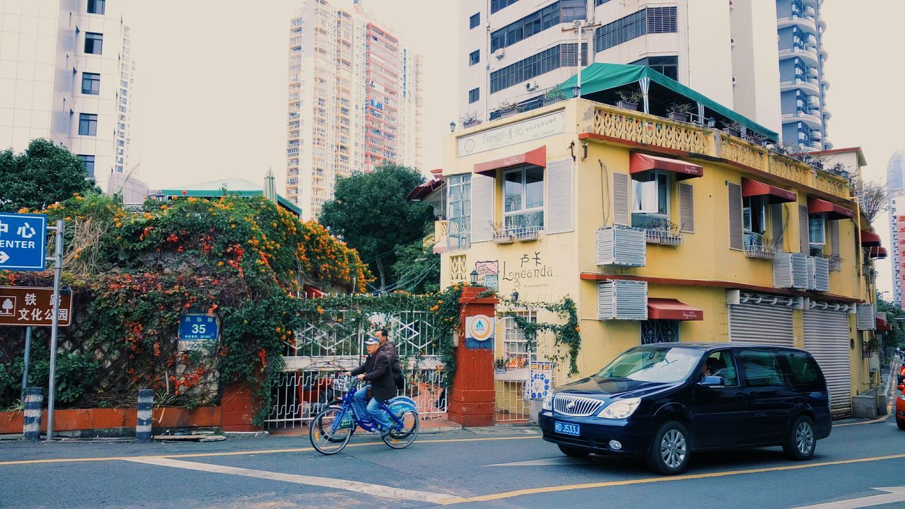 building exterior, architecture, built structure, street, land vehicle, city, transportation, mode of transport, car, bicycle, city life, residential building, building, residential structure, road, parking, sidewalk, parked, men