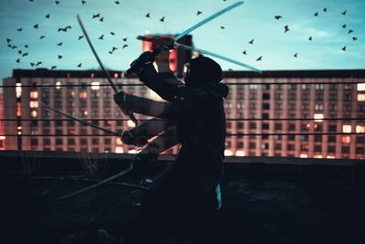 Side view of silhouette man playing against sky at night