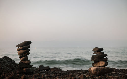 Stack of stones on beach against sky