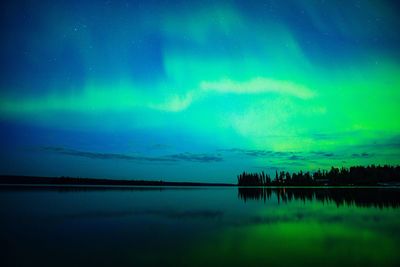 Scenic view of lake with aurora borealis reflection