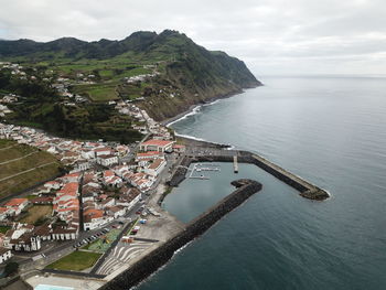 High angle view of townscape by sea against sky