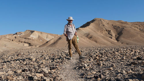 Senior man standing on rock in the desert 