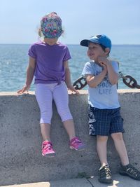 Full length of mother and daughter on sea shore