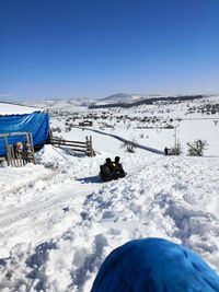 Scenic view of snow covered field against clear blue sky