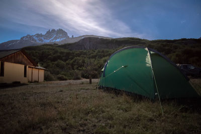 Tent on field by mountain against sky