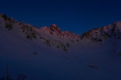 Low angle view of mountains against clear blue sky