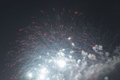 Low angle view of firework display at night