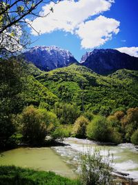Scenic view of river and mountains against sky