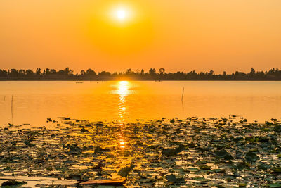 Scenic view of lake against orange sky