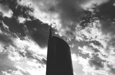 Low angle view of silhouette building against cloudy sky