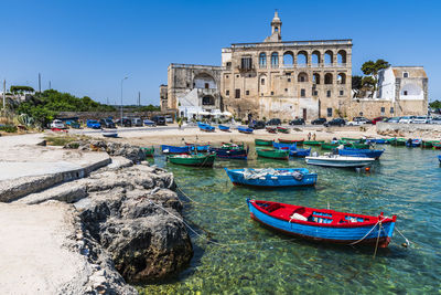 Boats moored in sea against buildings