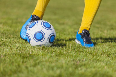 Low section of person playing soccer on field