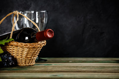 Close-up of wine bottle in basket on table