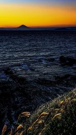 Scenic view of landscape against dramatic sky during sunset