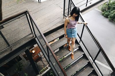 High angle view of mid adult woman moving down on steps in city