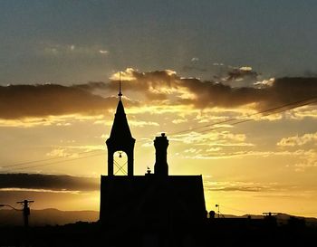 Silhouette of church against sky at sunset