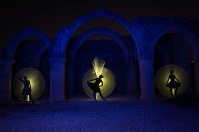 People in illuminated building at night