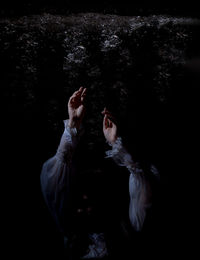 Low section of woman standing against black background