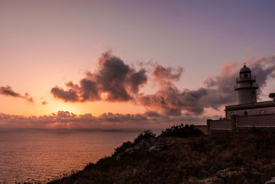 Scenic view of mediterranean sea and lighthouse against sky during sunrise at san antonio cape 