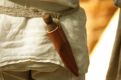 Midsection of person with tool in leather pouch