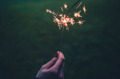 Close-up of hand holding illuminated sparkler